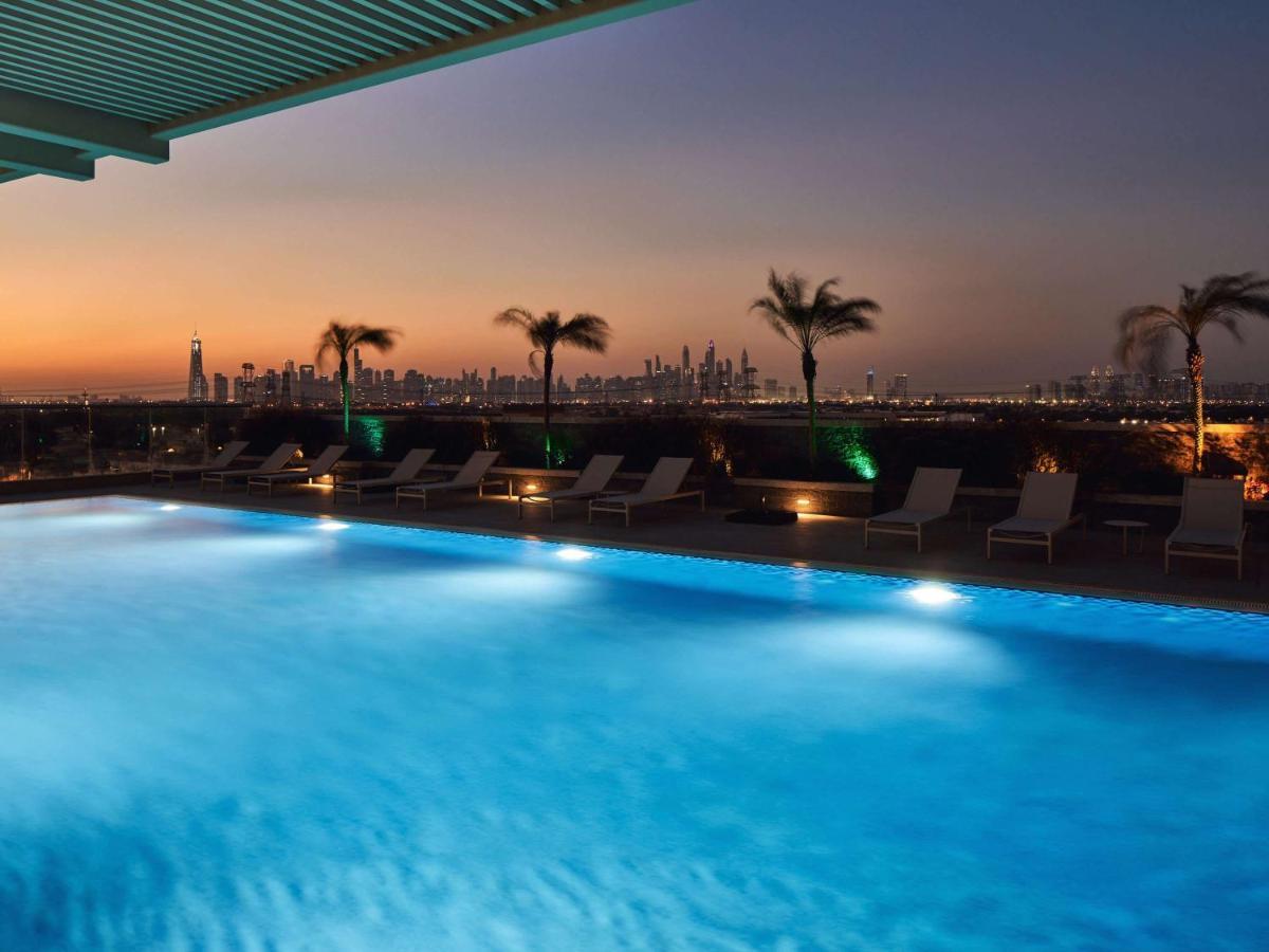 Movenpick Jumeirah Village Triangle Dubai Exterior foto The swimming pool at the hotel