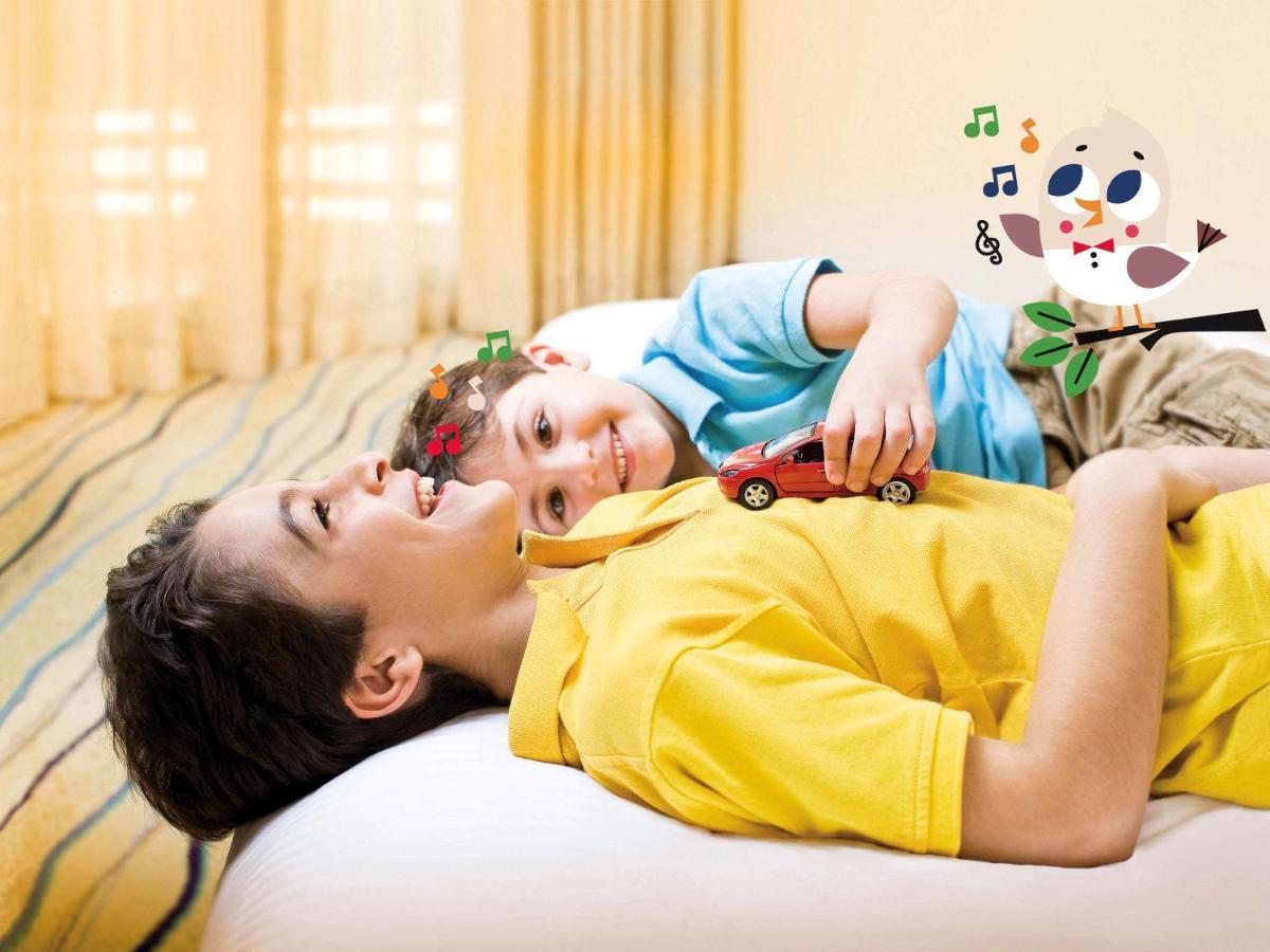 Movenpick Jumeirah Village Triangle Dubai Exterior foto A child with autism playing with a toy car
